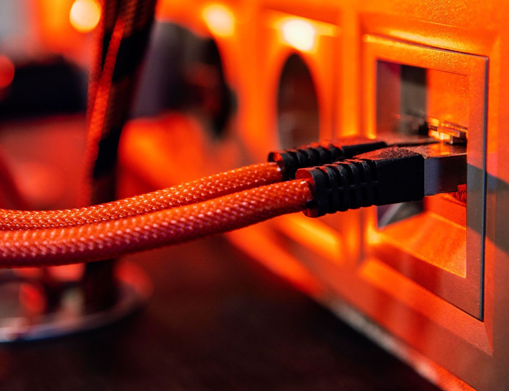 A close up of a pair of ethernet cables plugged into a computer.