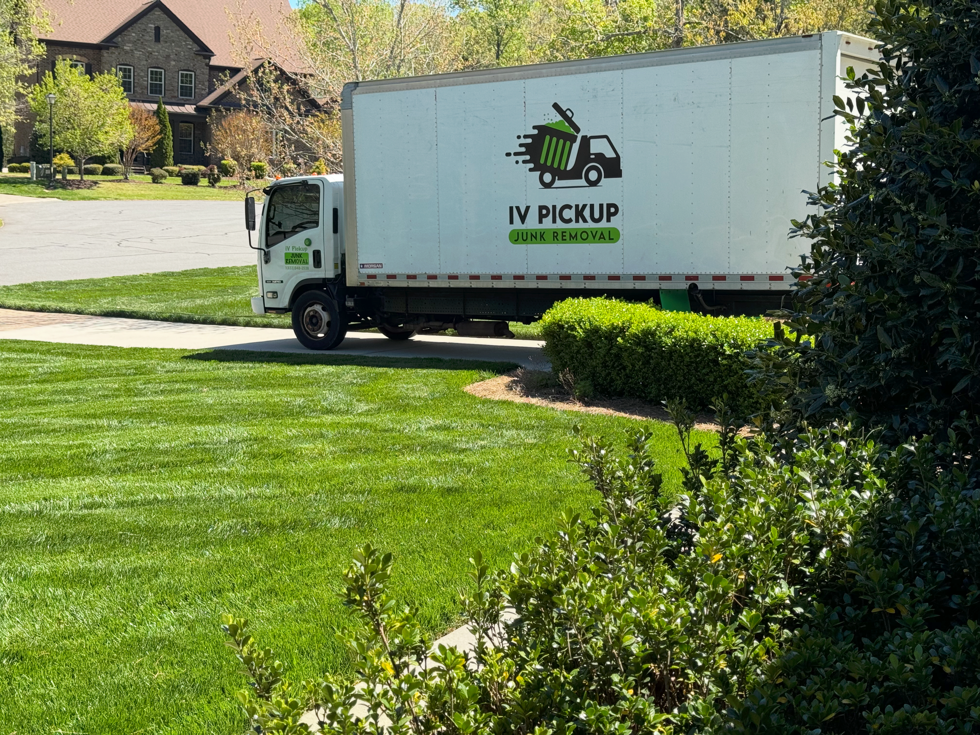 A blue dumpster is sitting in front of a house under construction.