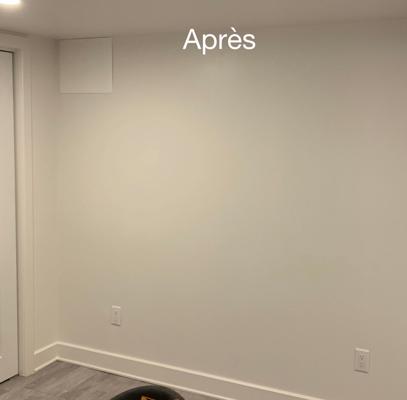 Une pièce avec des murs blancs et une chaise noire dedans.