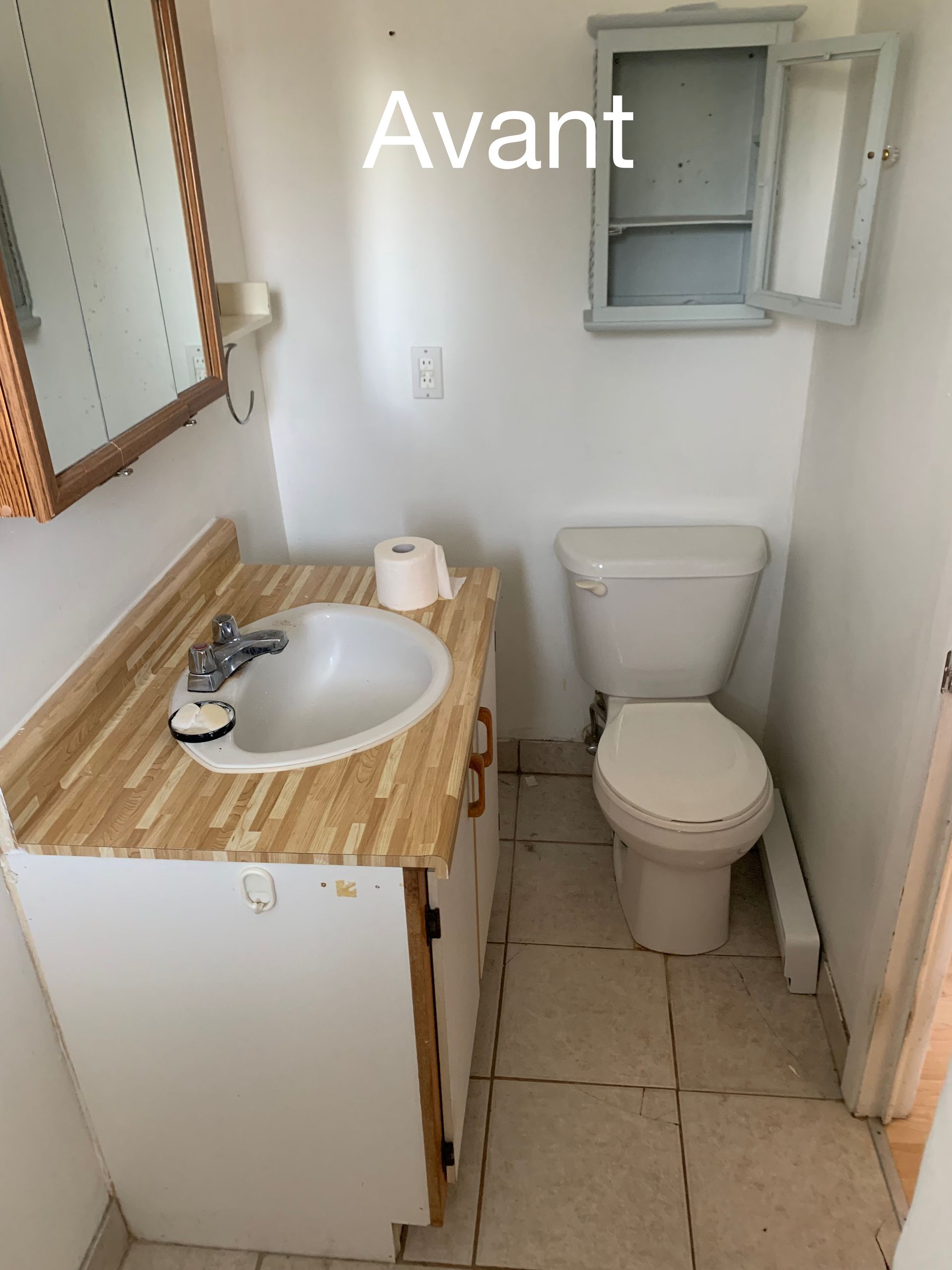 Une salle de bain avec des toilettes, un lavabo et un miroir avec le mot avant au-dessus