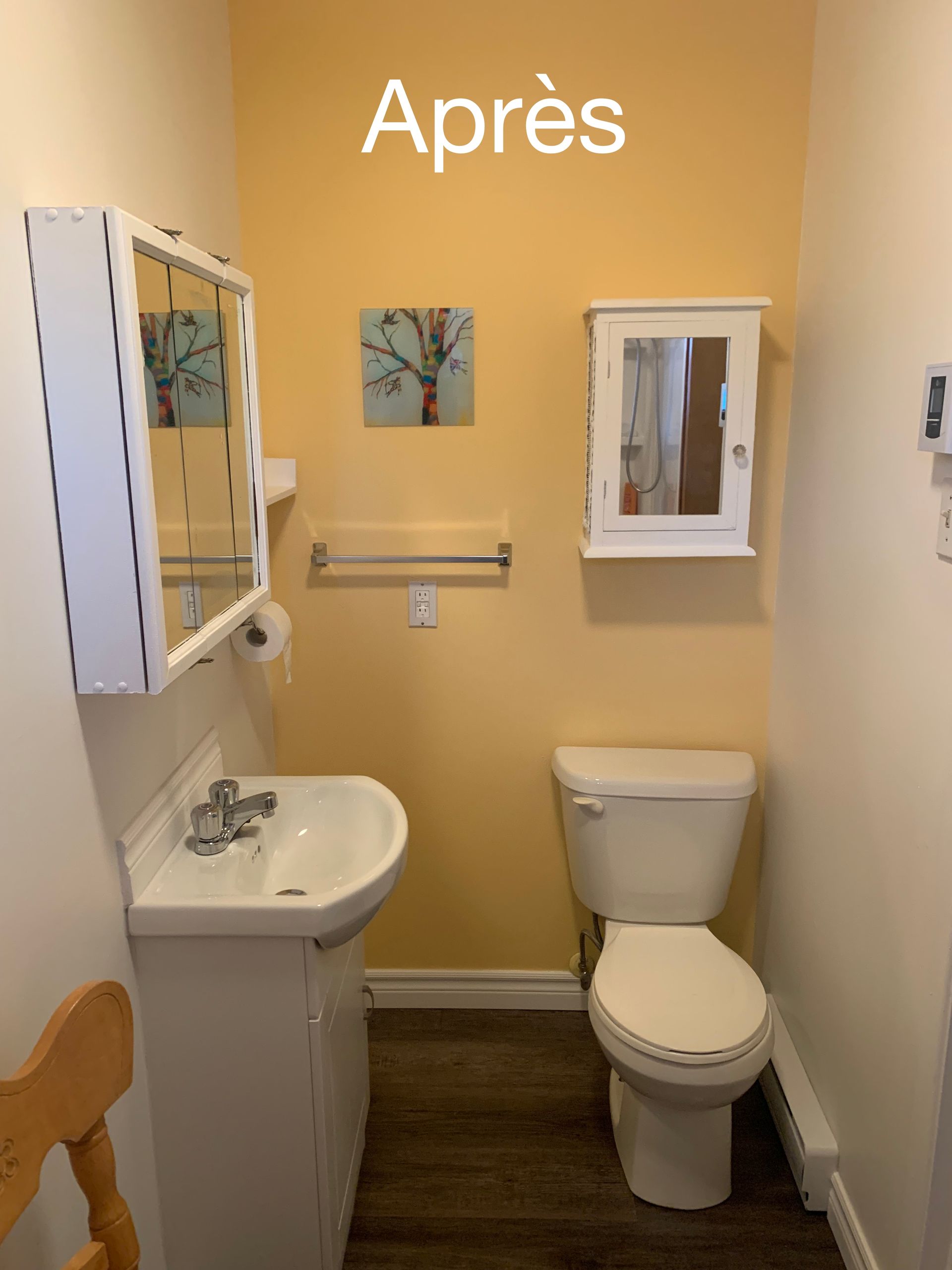 Une salle de bain avec des murs jaunes et des toilettes et un lavabo