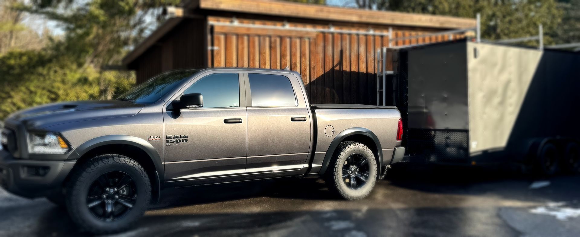 Un camion gris tracte une remorque sur un parking.