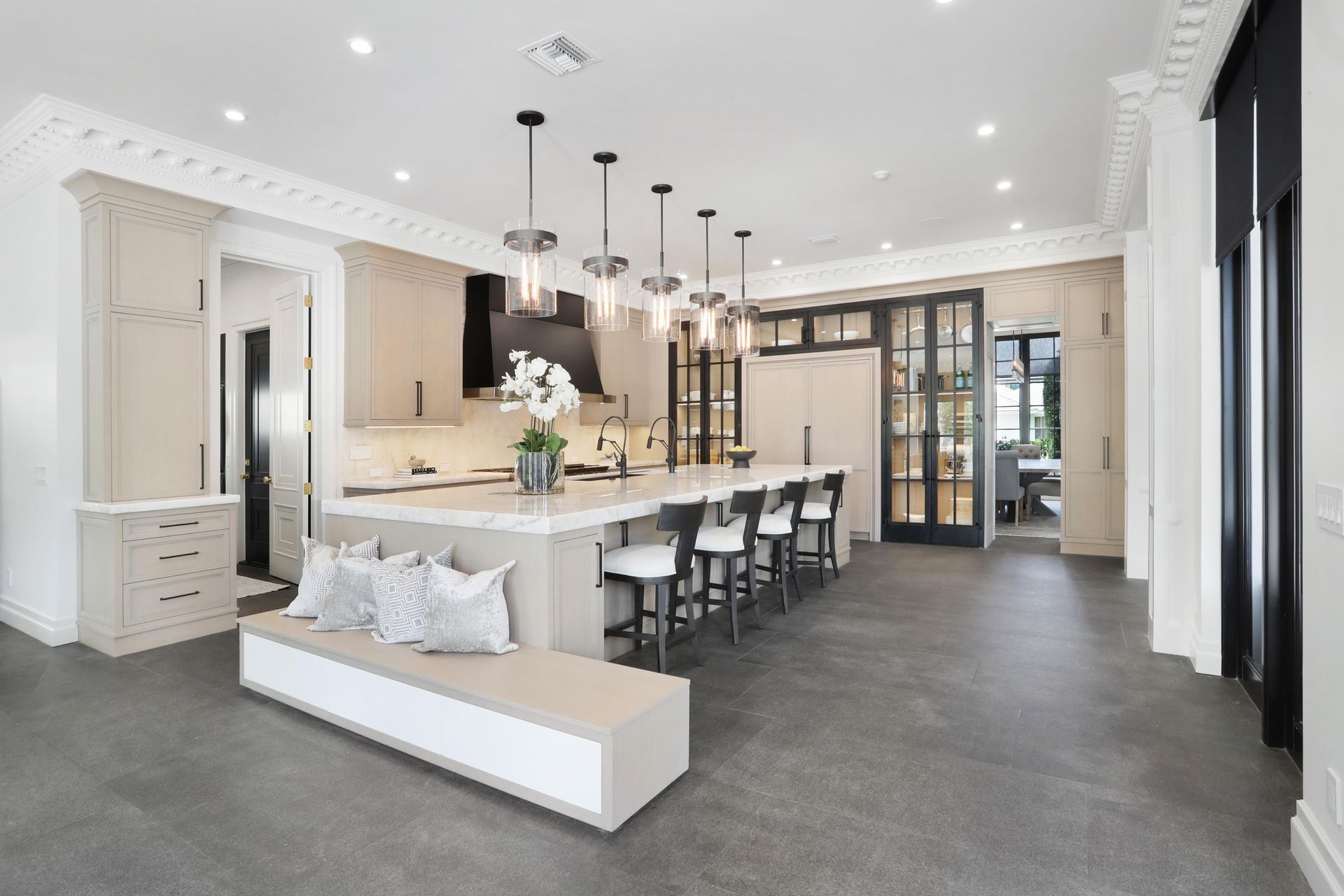 A kitchen with white cabinets and a large island in the middle.