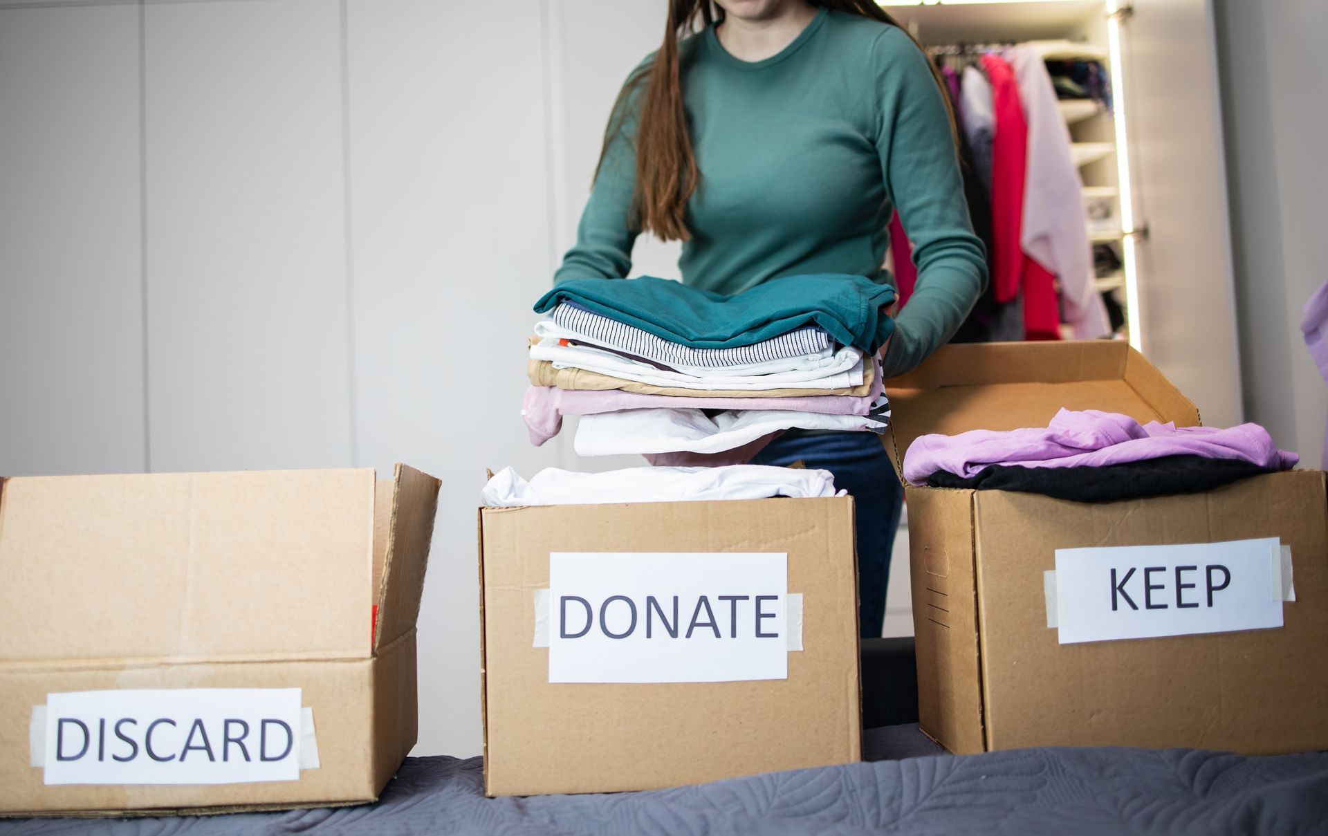 Woman sorting clothes into boxes labeled 