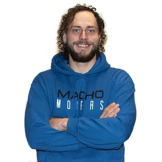 a man wearing a blue macho mofas hoodie with his arms crossed