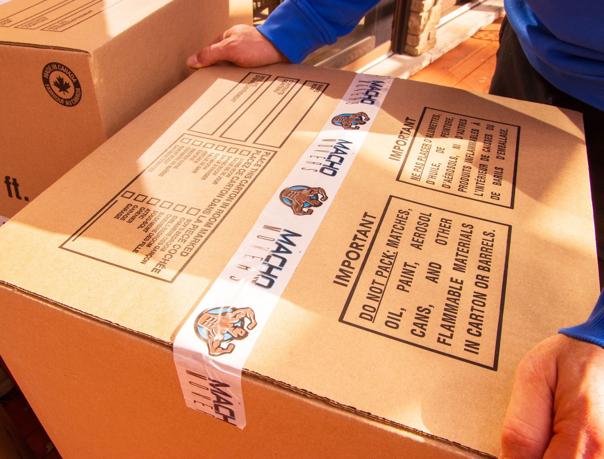 a woman is putting a label on a cardboard box .