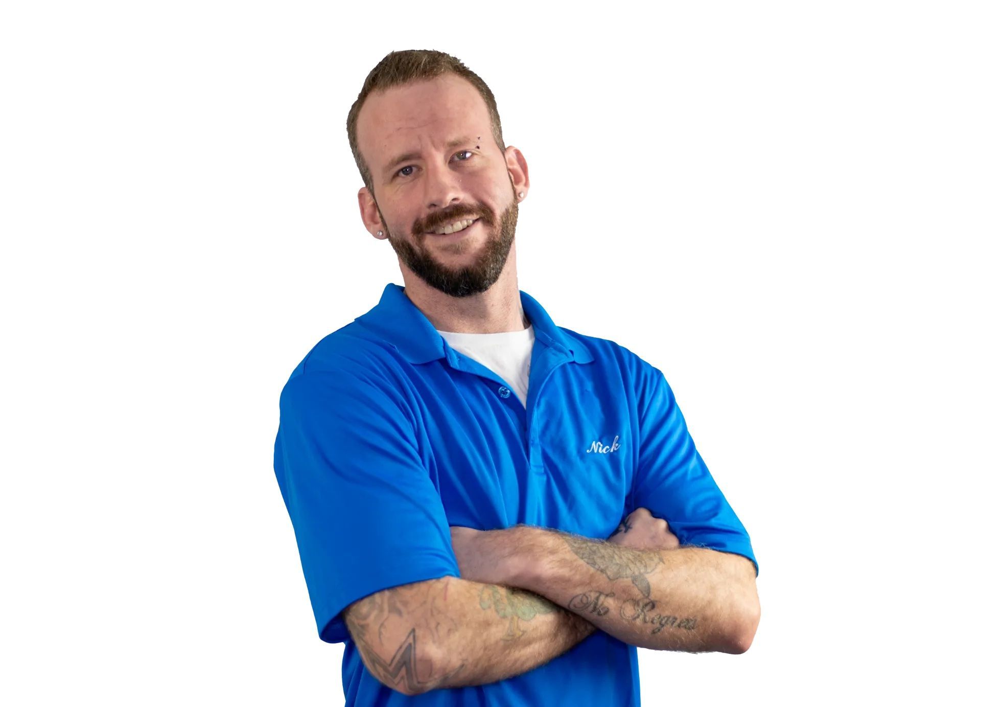 a man with a beard is wearing a blue polo shirt with his arms crossed .