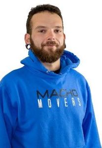 a man with a beard is wearing a blue polo shirt with his arms crossed .