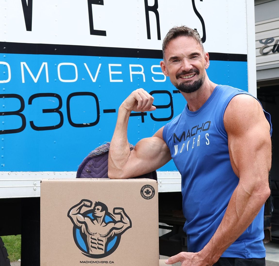 a delivery man is holding a cardboard box in his hand .