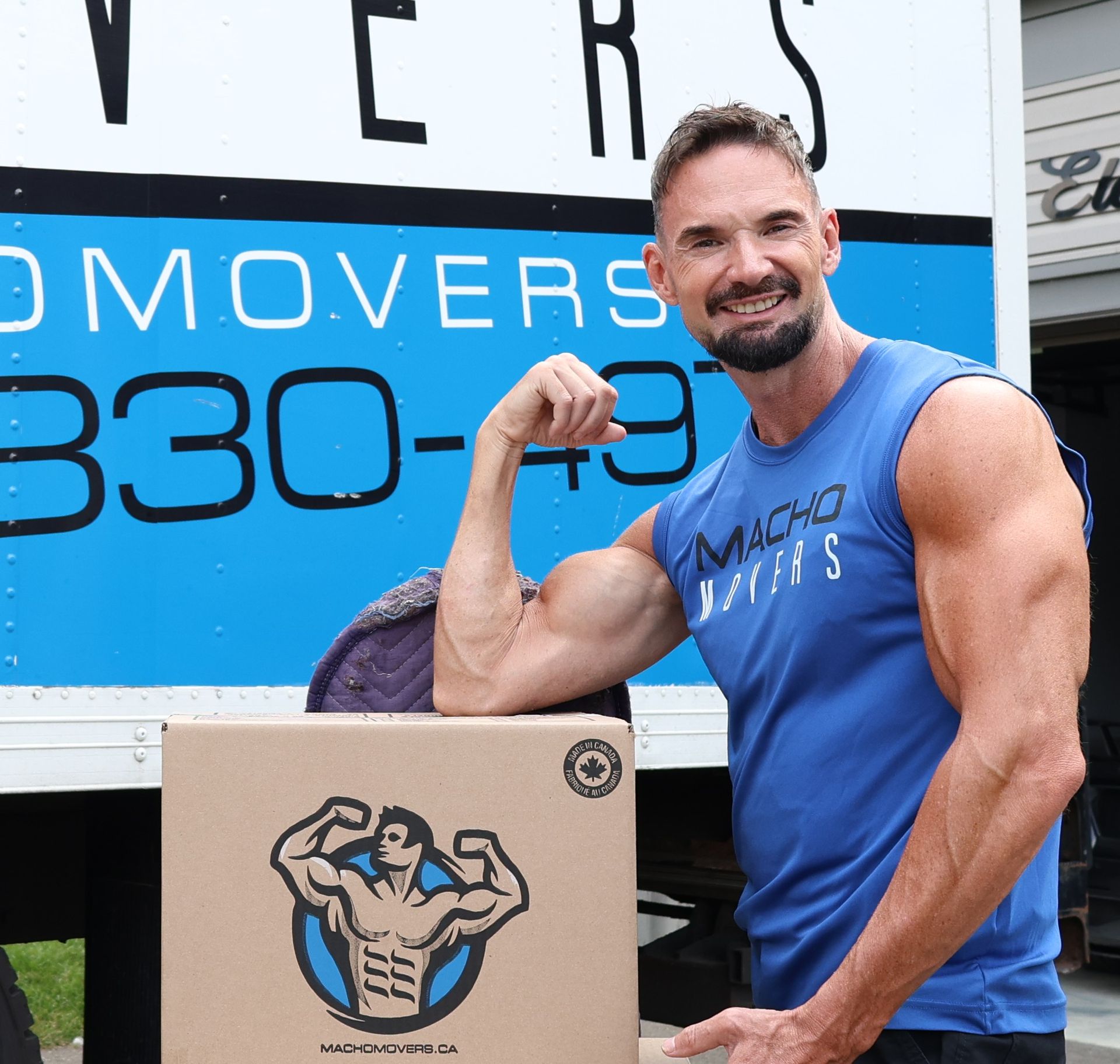 a delivery man is holding a cardboard box in his hand .
