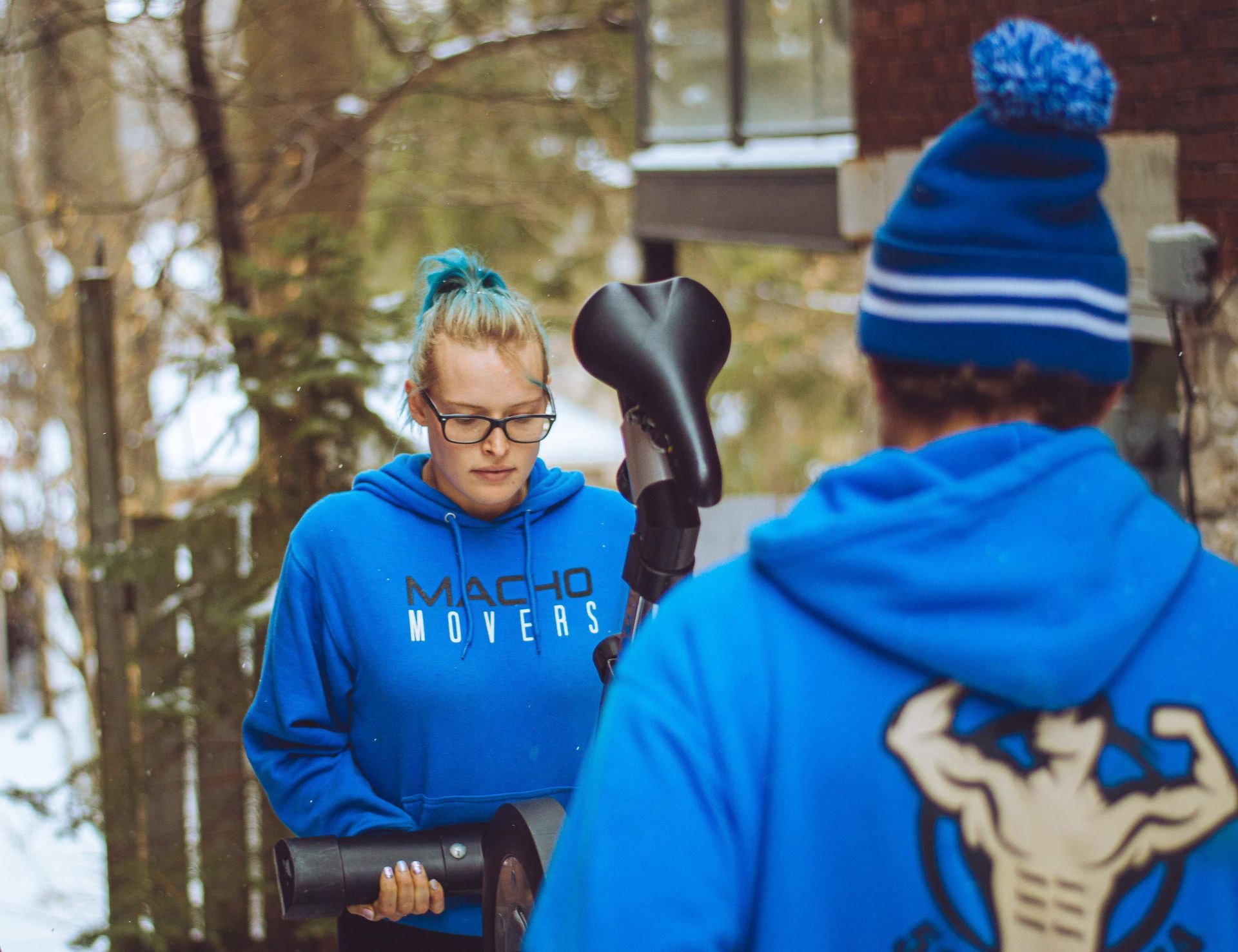 a woman in a blue hoodie is standing next to a man in a blue hat .