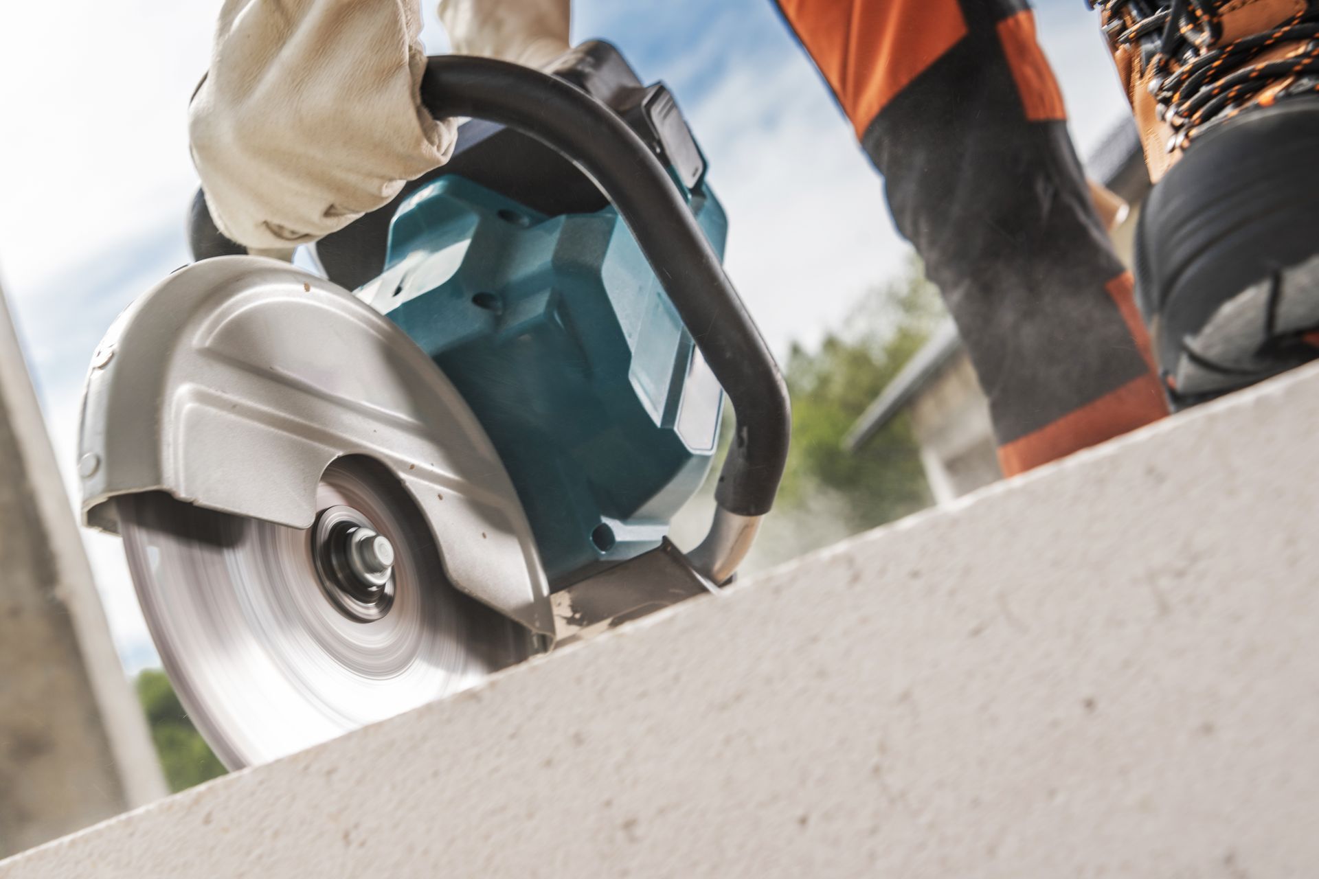 A large orange excavator is sitting on top of a dirt field.