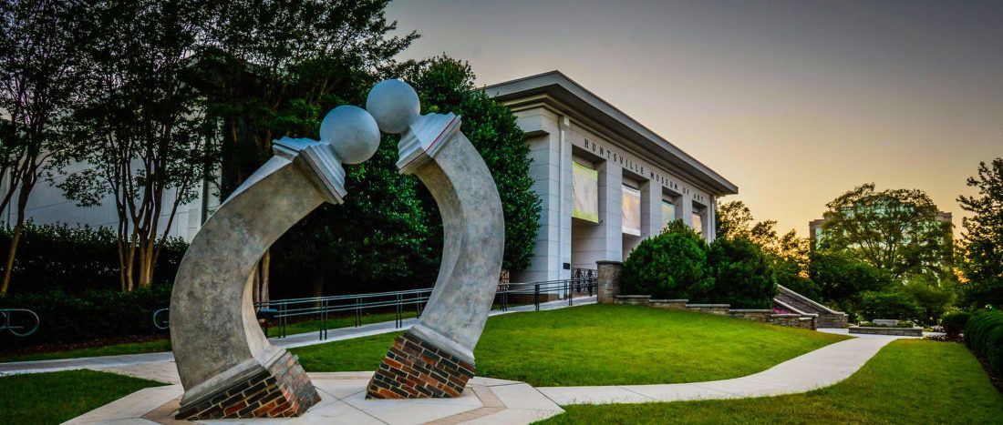 A large white building with a sculpture in front of it.