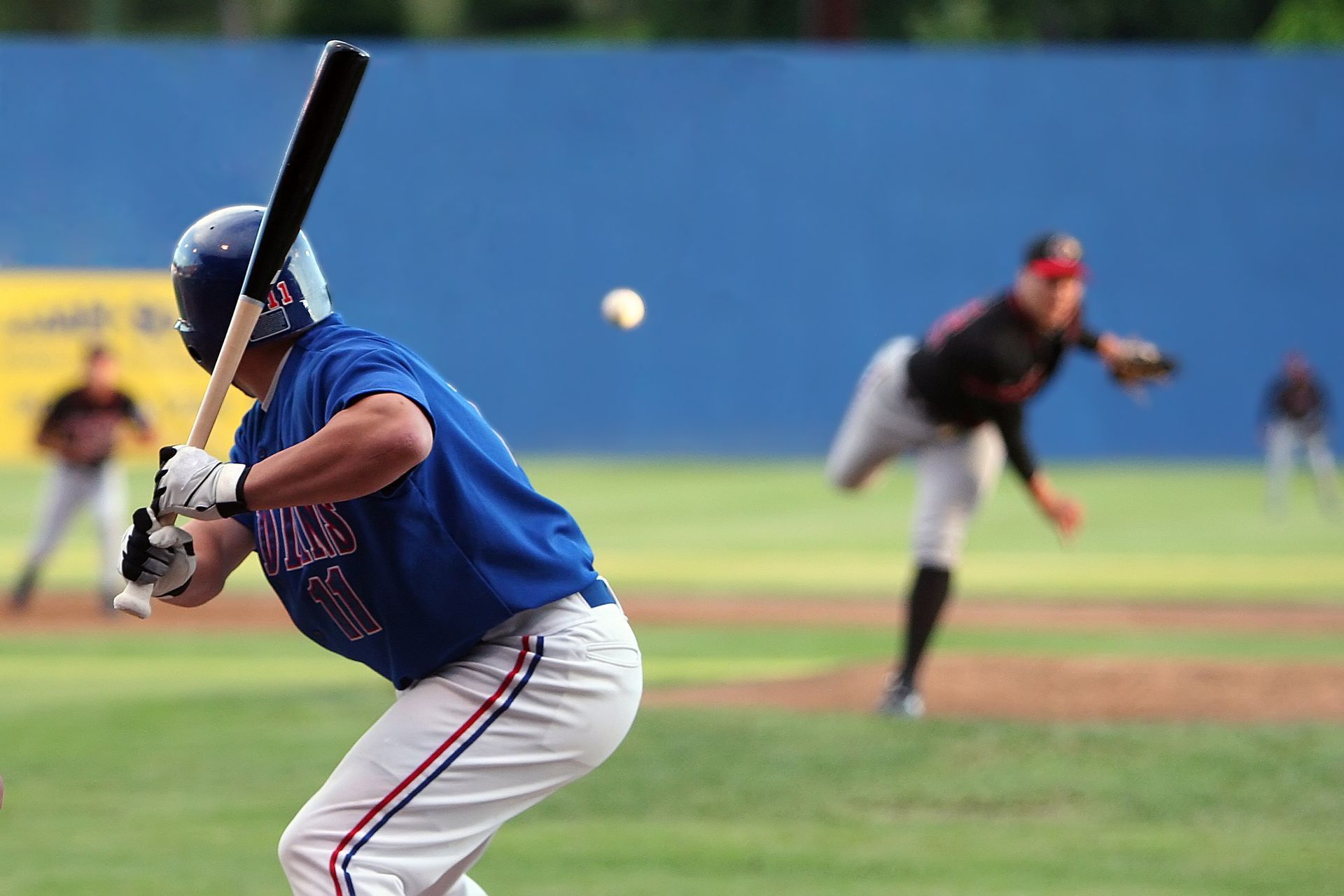 A baseball player in a blue jersey is swinging a bat at a ball.