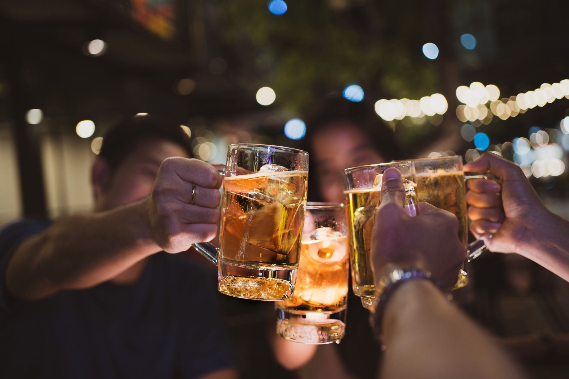 A group of people are toasting with beer mugs.
