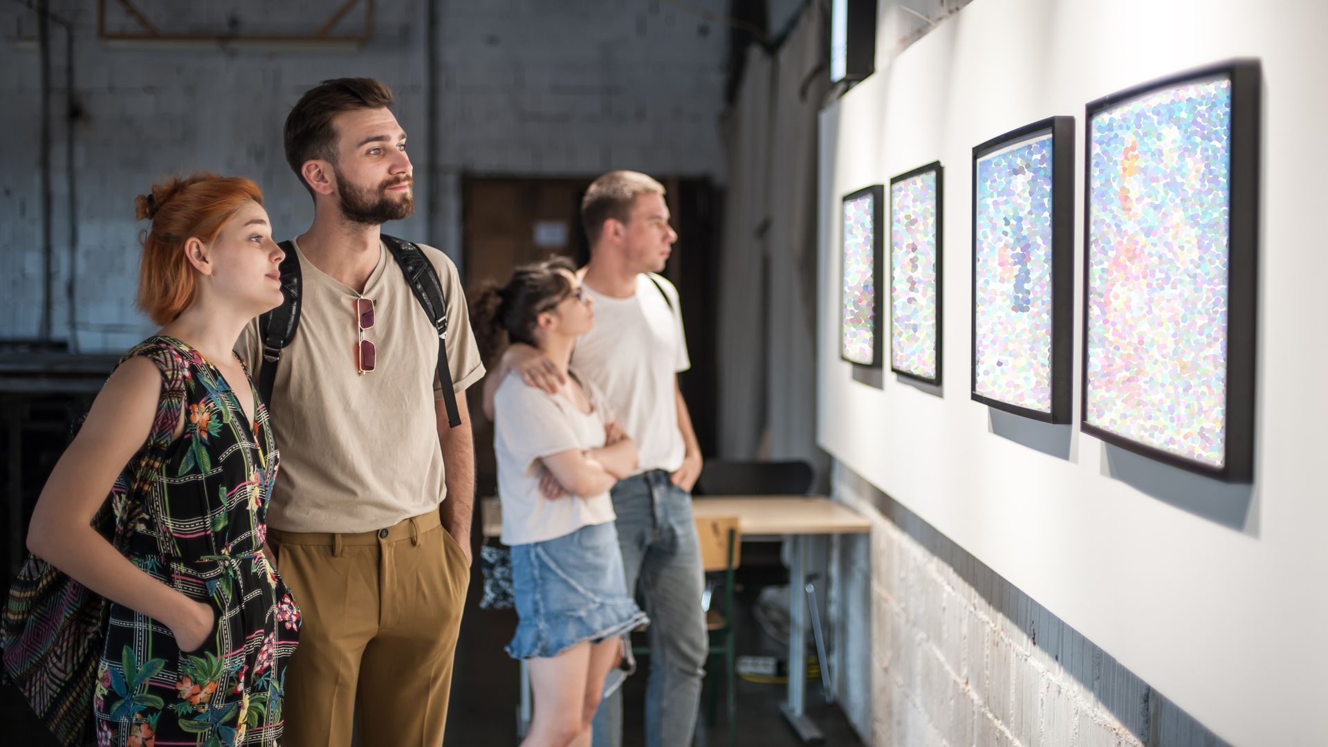 A group of people are looking at a painting in an art gallery.