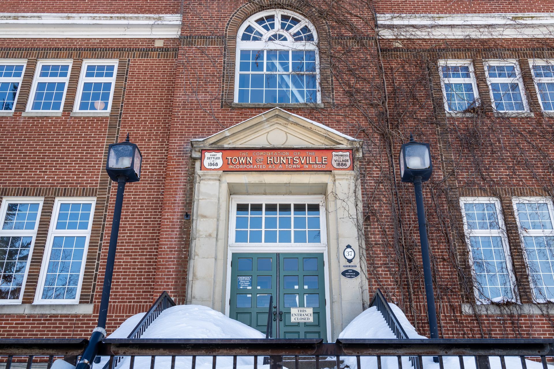 The front of a brick building with a green door