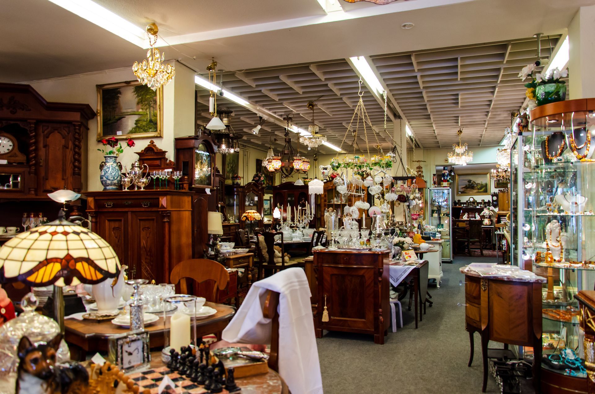 A store filled with lots of antique items including a stained glass lamp
