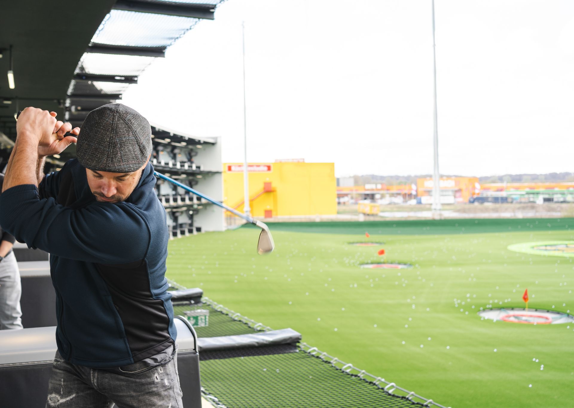 A man is swinging a golf club at a golf course.