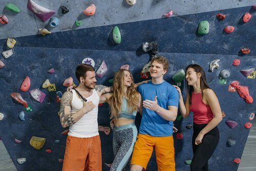 A group of people are standing in front of a climbing wall.