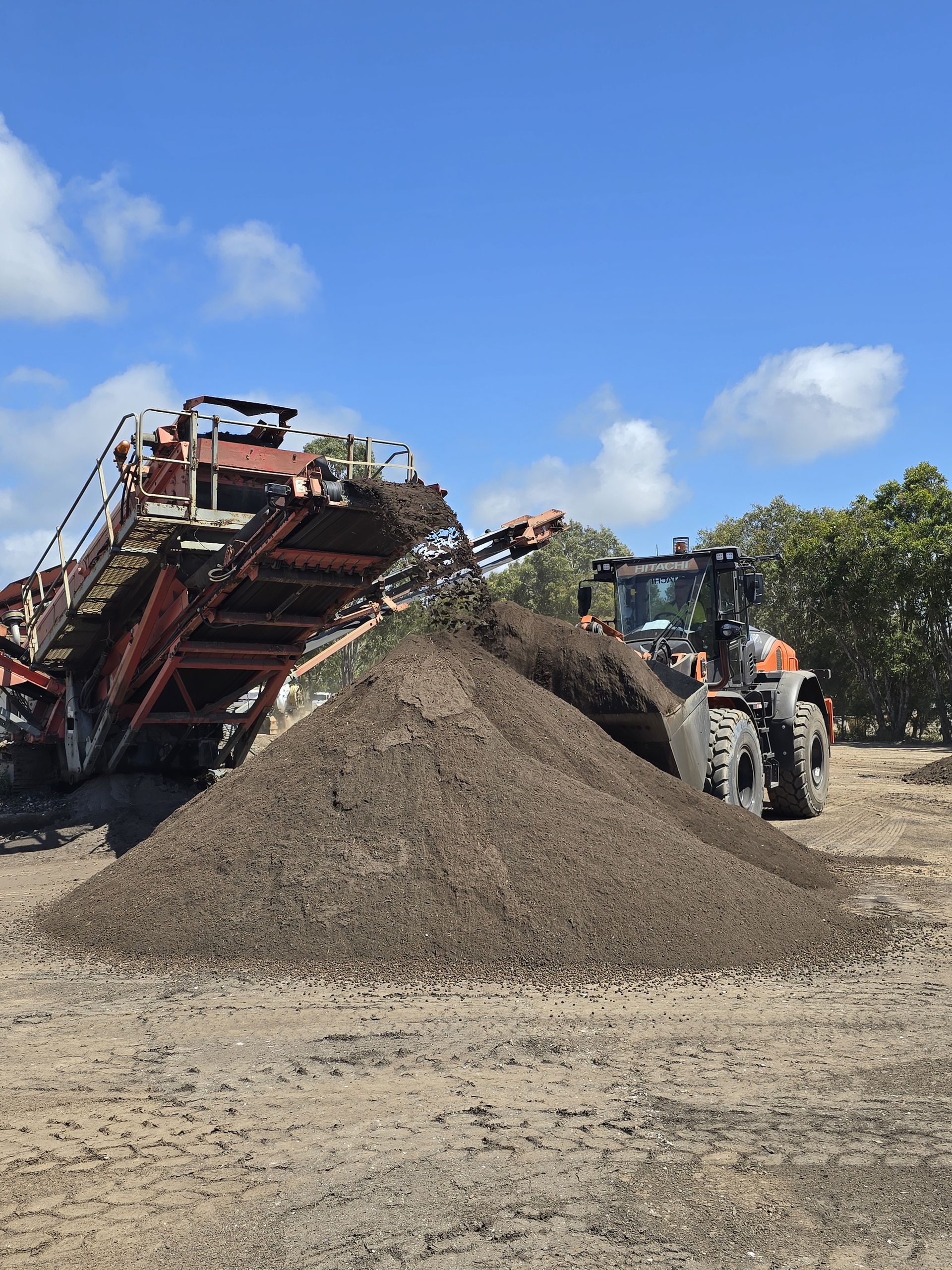Large Pile of Brown Mulch Under a Clear Blue Sky — Coastal Sand Soil & Mulch In Craignish, QLD