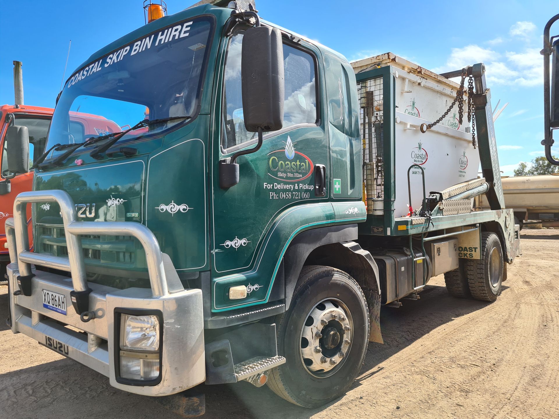 Skip Bin Truck With a White Skip Bin on Its Tray — Coastal Sand Soil & Mulch in Craignish, QLD