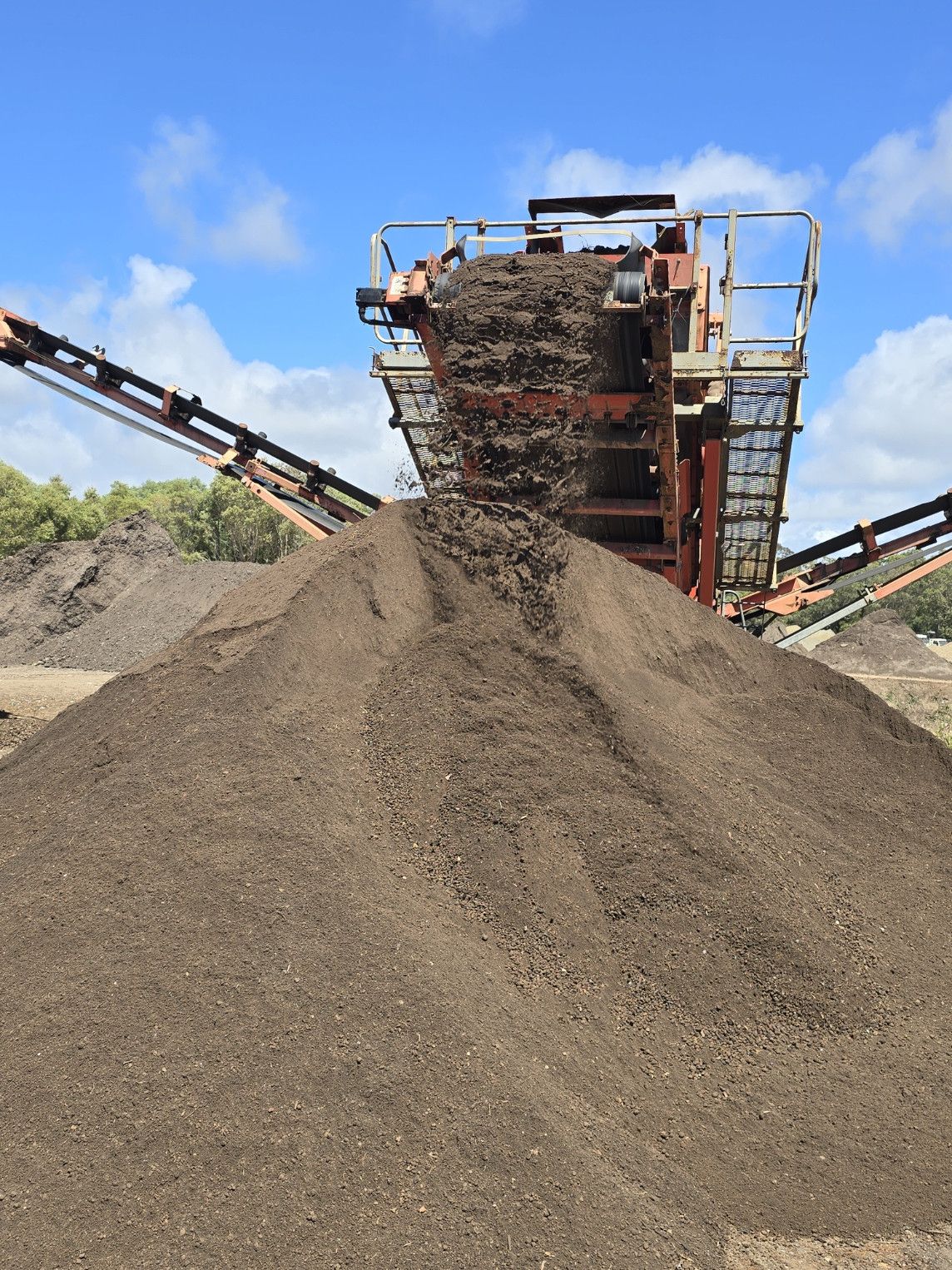 Large White Bags Filled with Dark Soil, Blue Handles — Coastal Sand Soil & Mulch in Maryborough, QLD