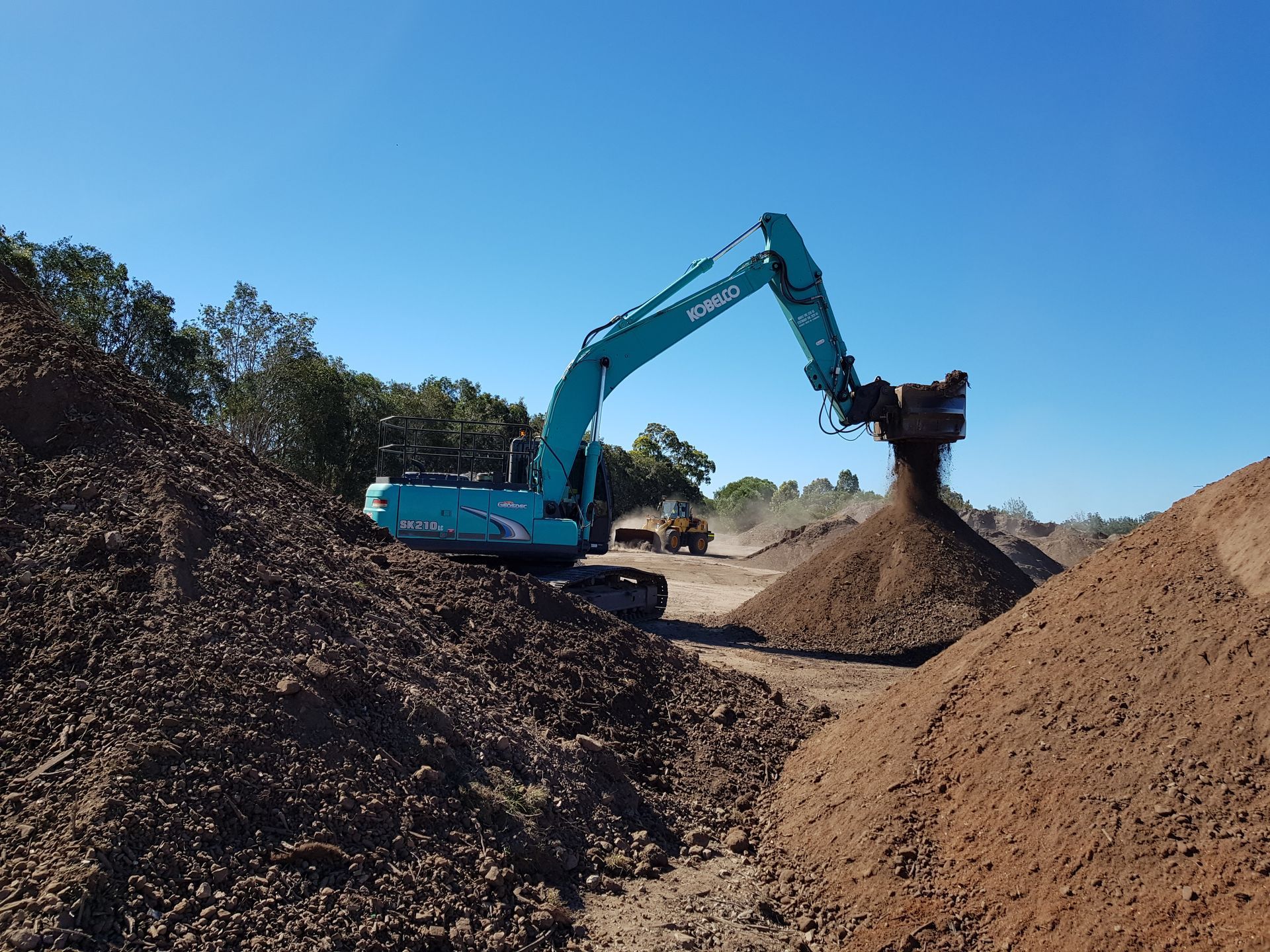 Piles of Gravel and Earth Next to a Conveyor Belt — Coastal Sand Soil & Mulch in River Heads, QLD