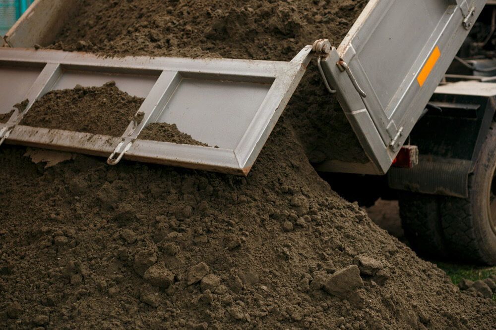 Dump Truck Bed Tilted, Unloading Brown Soil Onto a Pile — Coastal Sand Soil & Mulch in Craignish, QLD