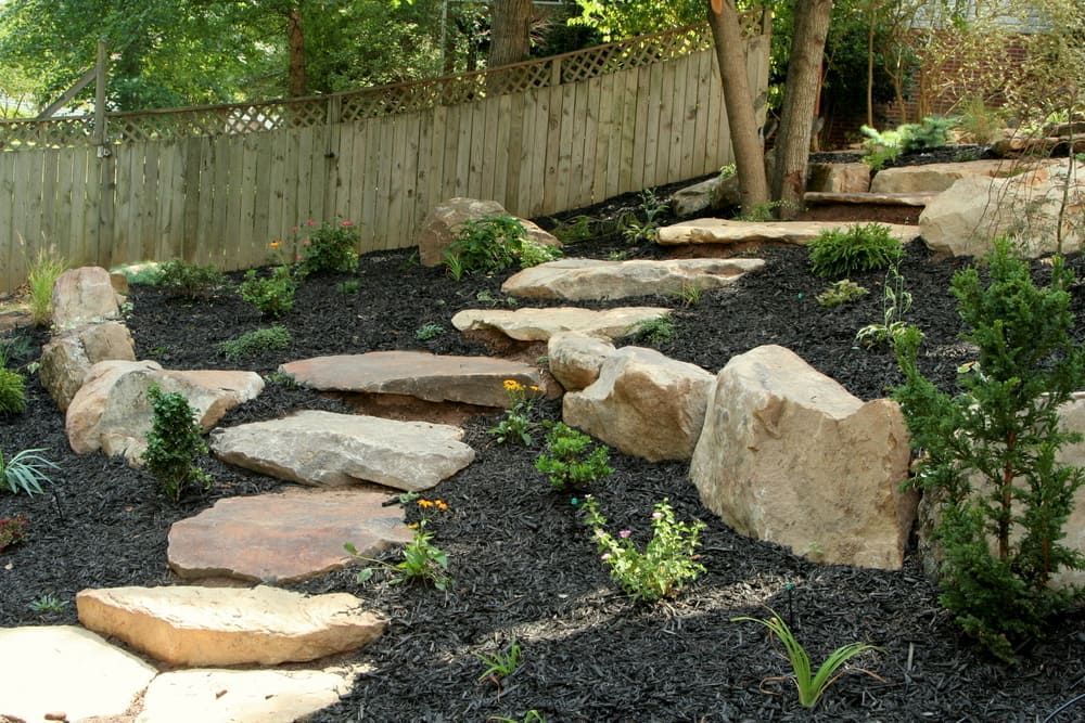 Stone Pathway Winds Up a Hillside Garden with Black Mulch — Coastal Sand Soil & Mulch in Point Vernon, QLD