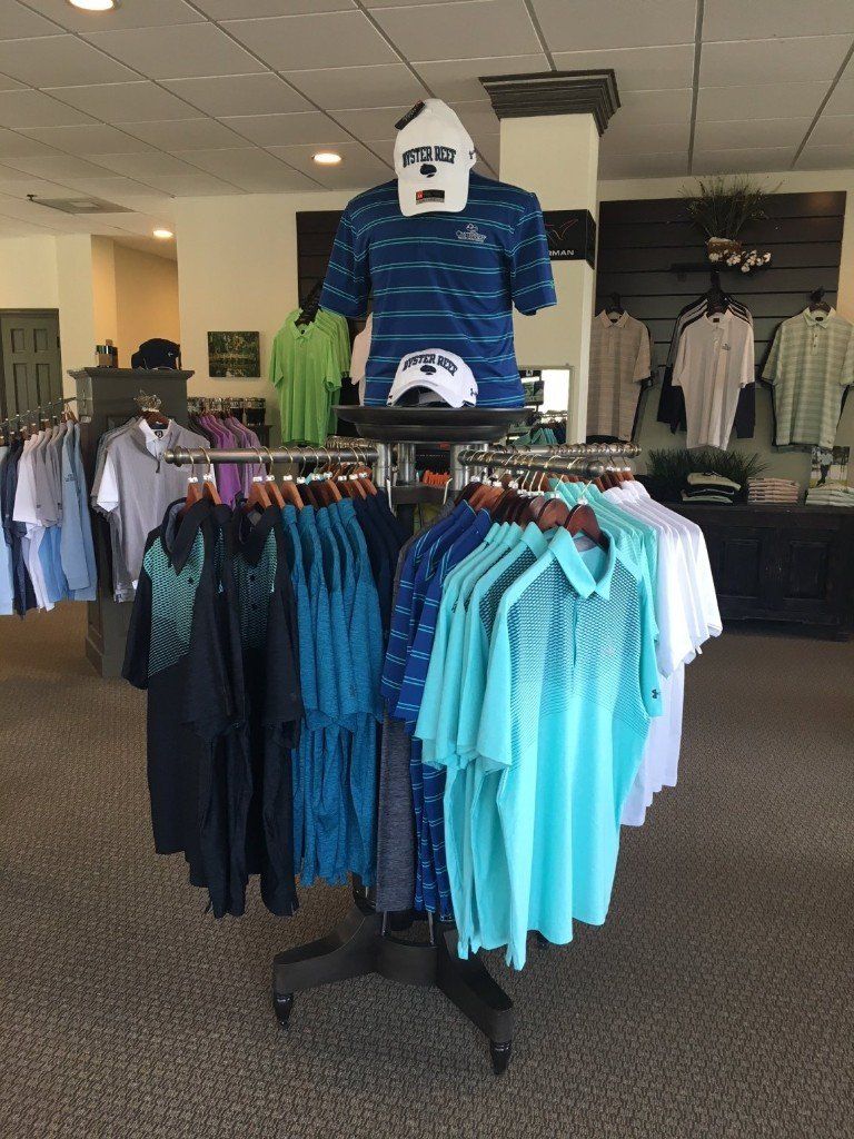 Golf shop fixtures showcasing colorful golf shirts, with a mannequin dressed in a blue shirt and cap as the centerpiece.