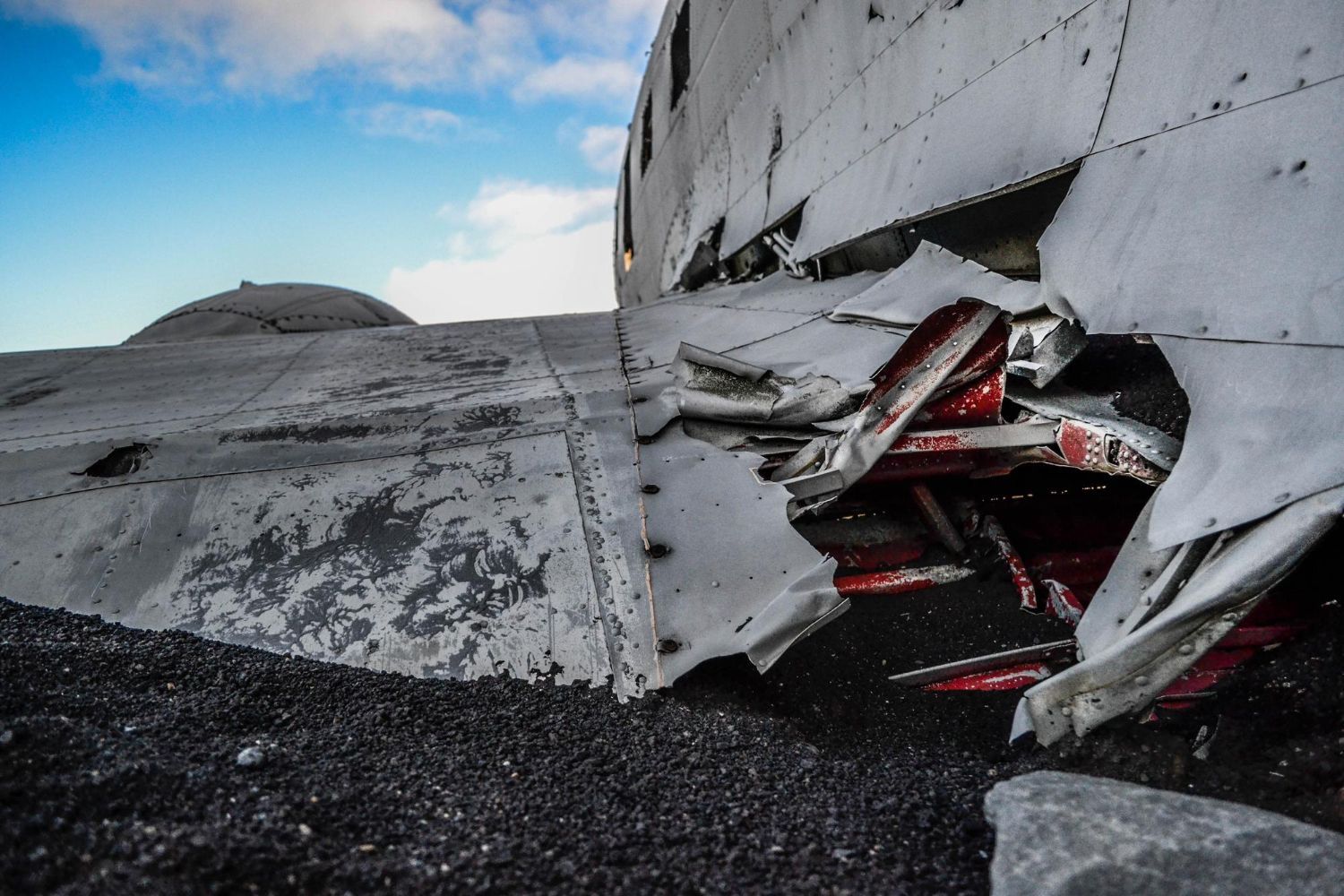 Mechanic inspecting a truck engine with the hood open, outdoors.