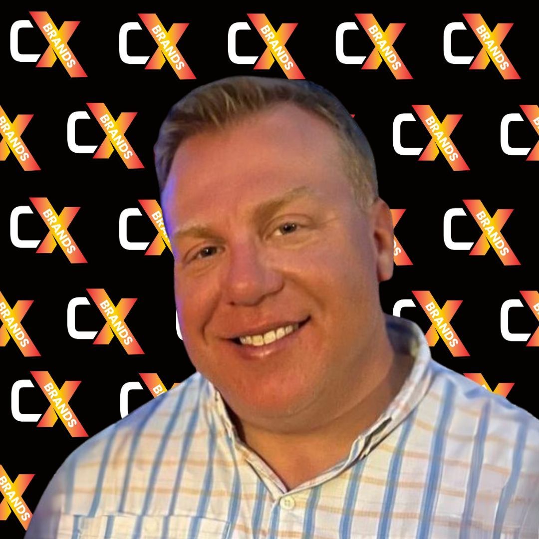 A man is smiling in front of a sign that says the expo