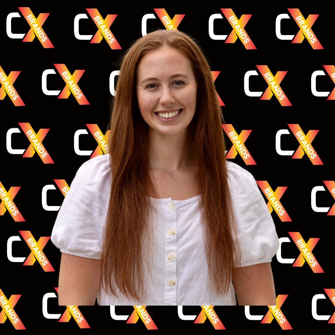 A woman is smiling in front of a black background with the word expo on it.