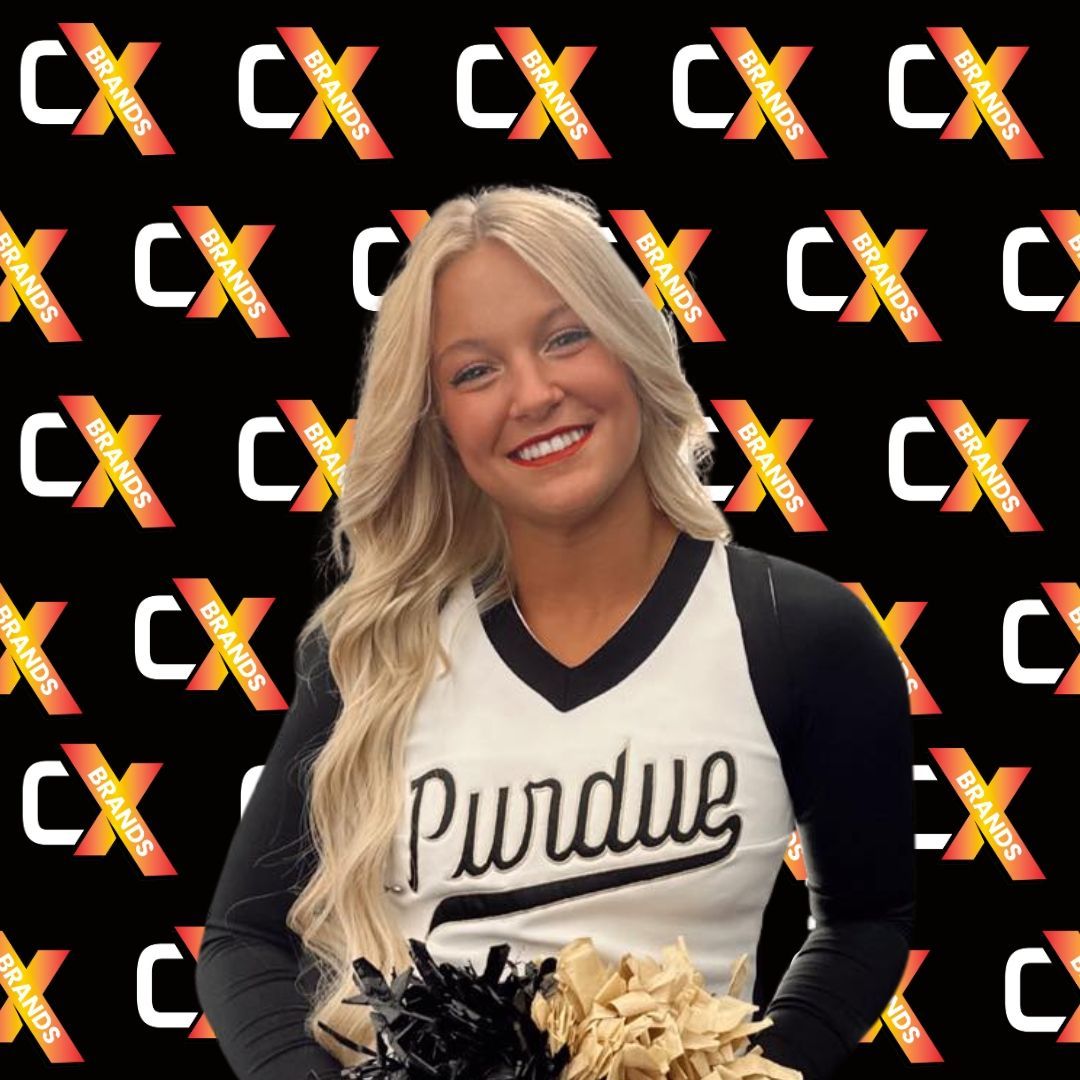 A man with a beard is smiling in front of a sign that says the expo