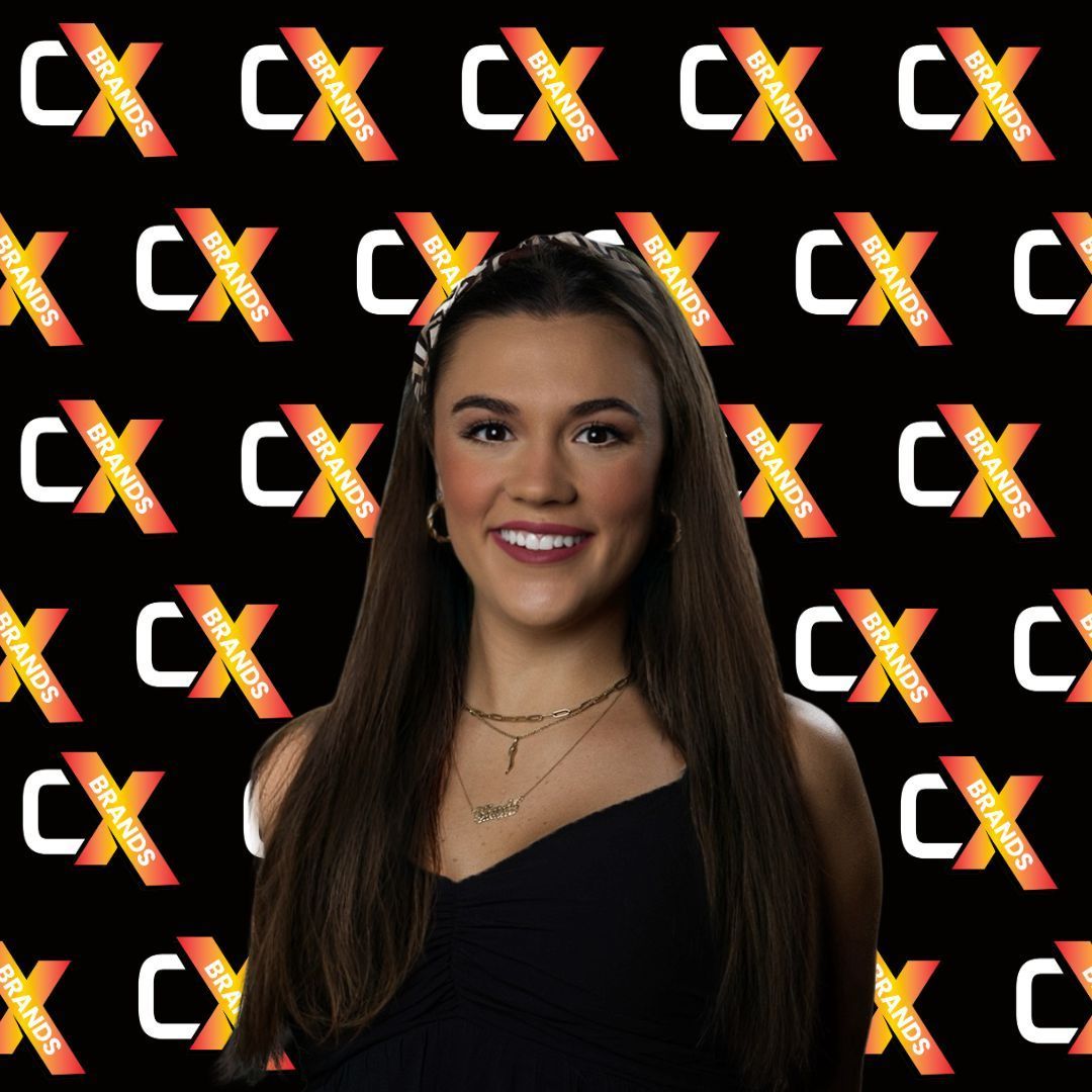 A man with a beard is smiling in front of a sign that says the expo