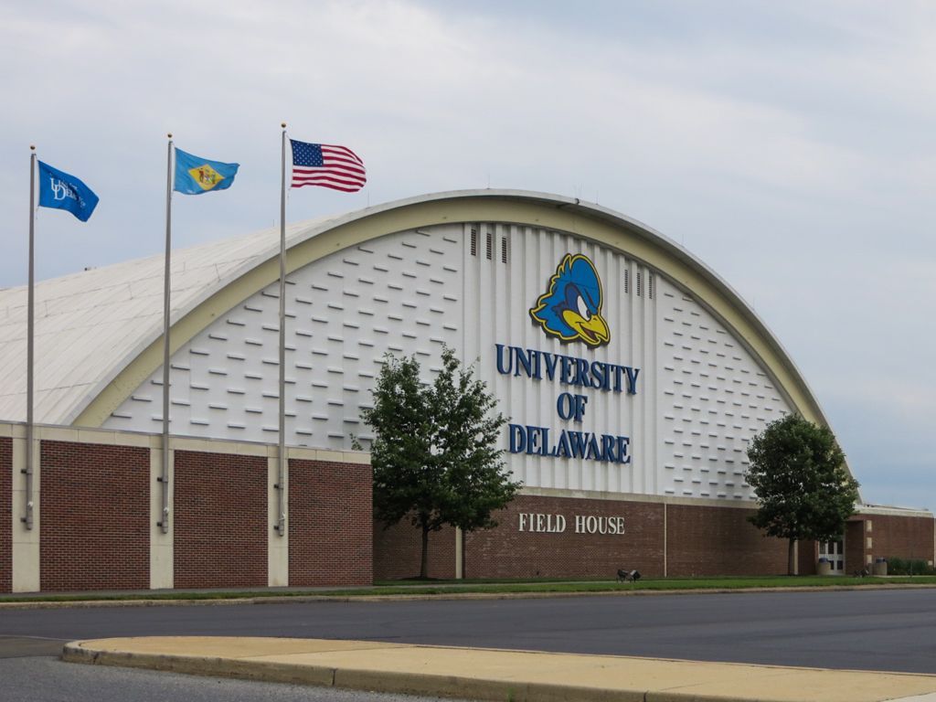 A university of delaware building with flags flying in front of it