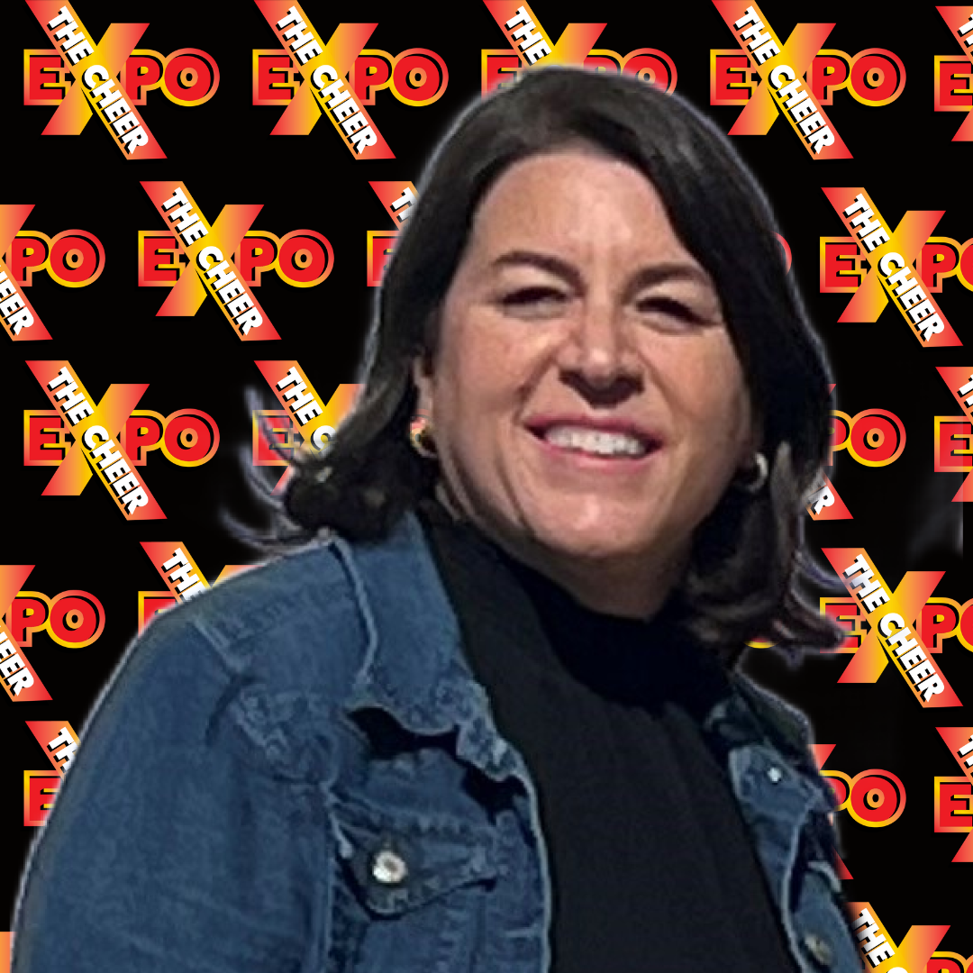 A woman in a denim jacket is smiling in front of a black background with the word expo on it.