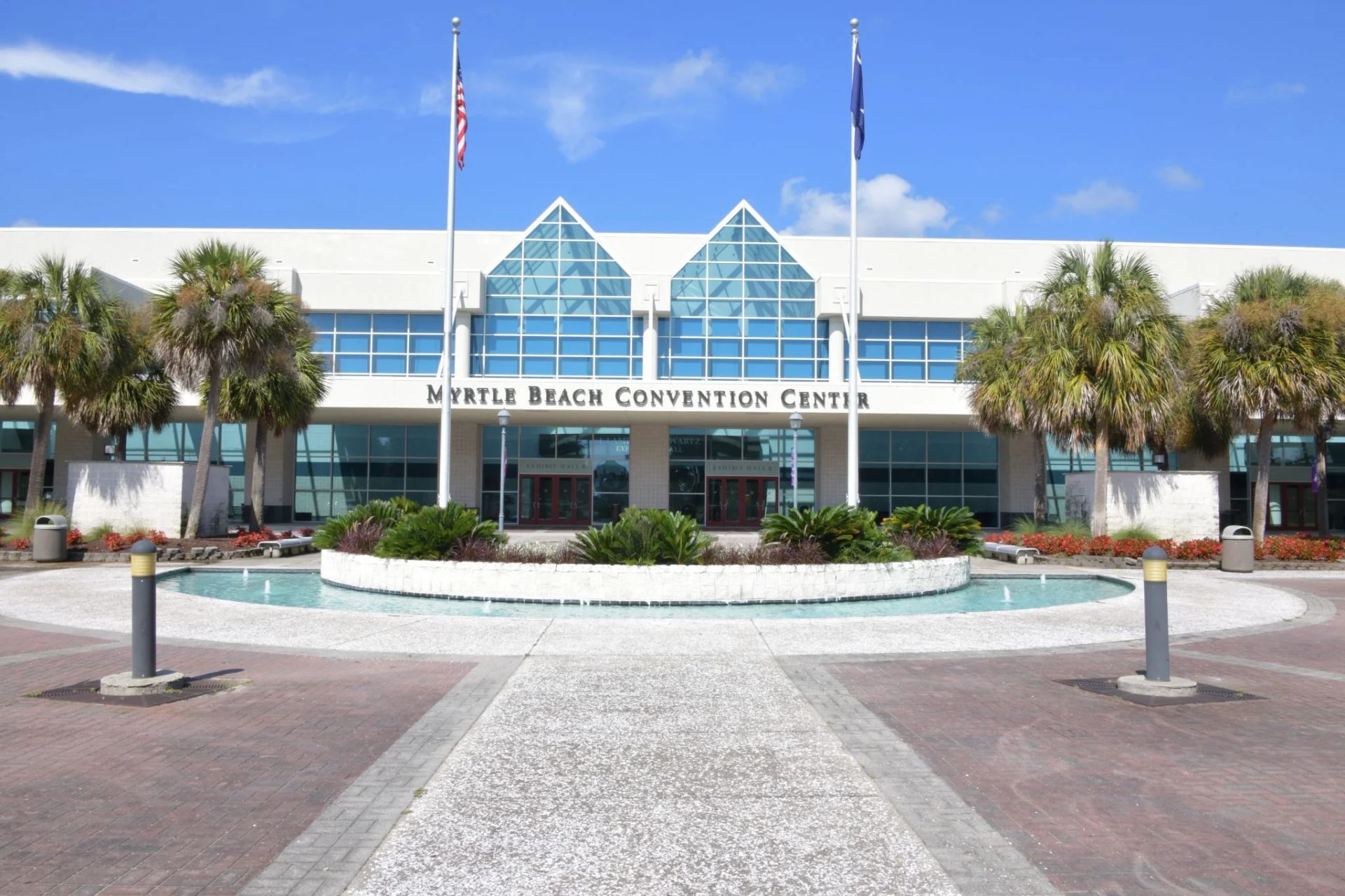 A large building with three flags flying in front of it.