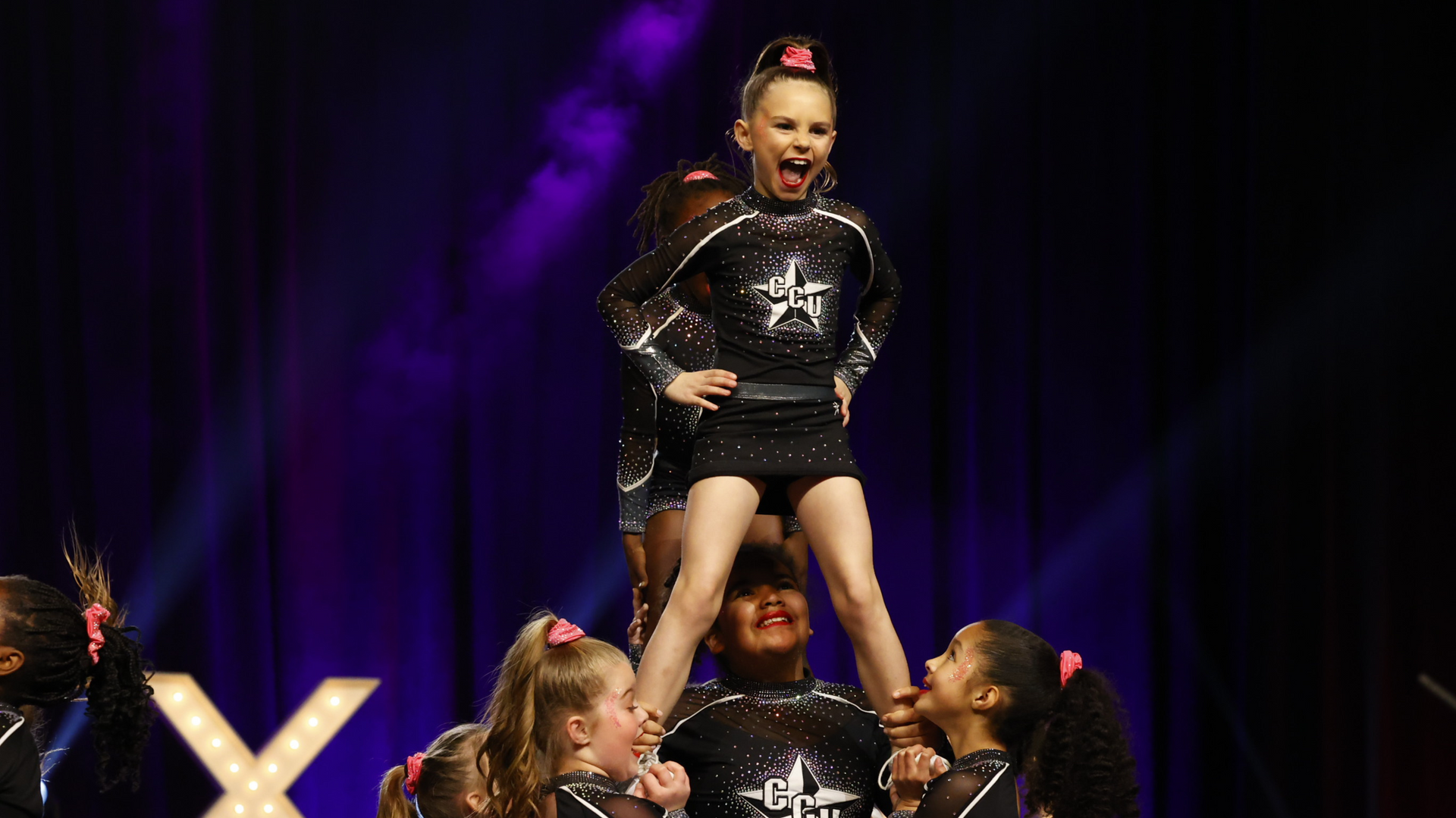 A group of cheerleaders are performing on a stage.