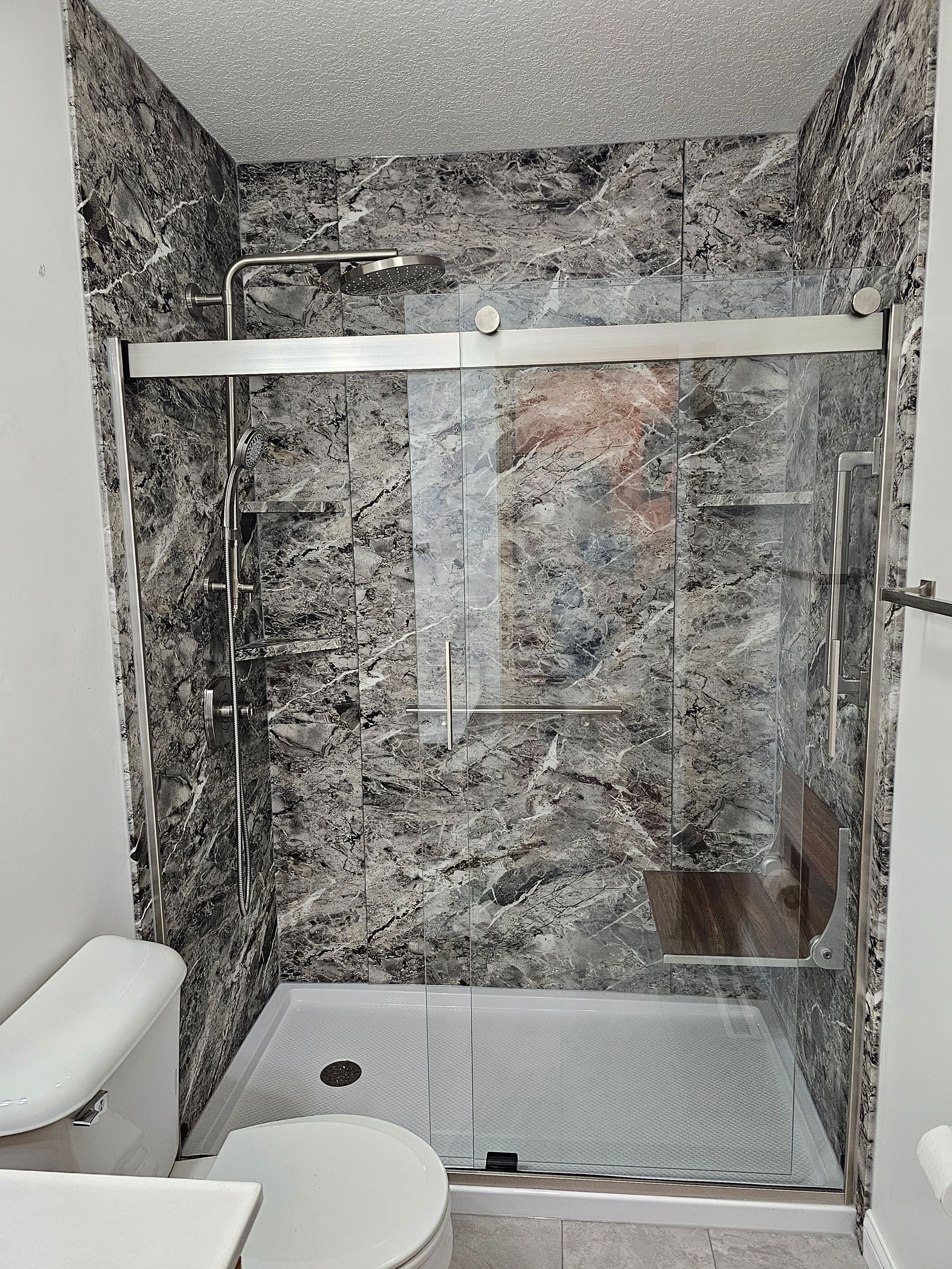 A bathroom with a toilet , sink , and shower stall.