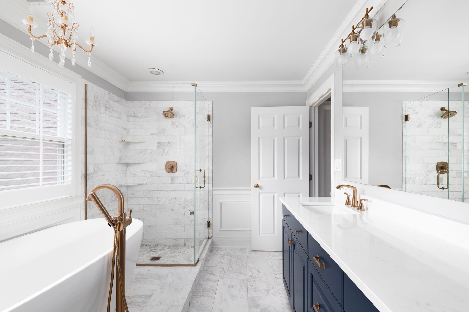 A beautiful bathroom with a blue vanity cabinet, standalone bathtub, shower, and gold faucets A beautiful bathroom with a blue vanity cabinet, standalone bathtub, shower, and gold faucets