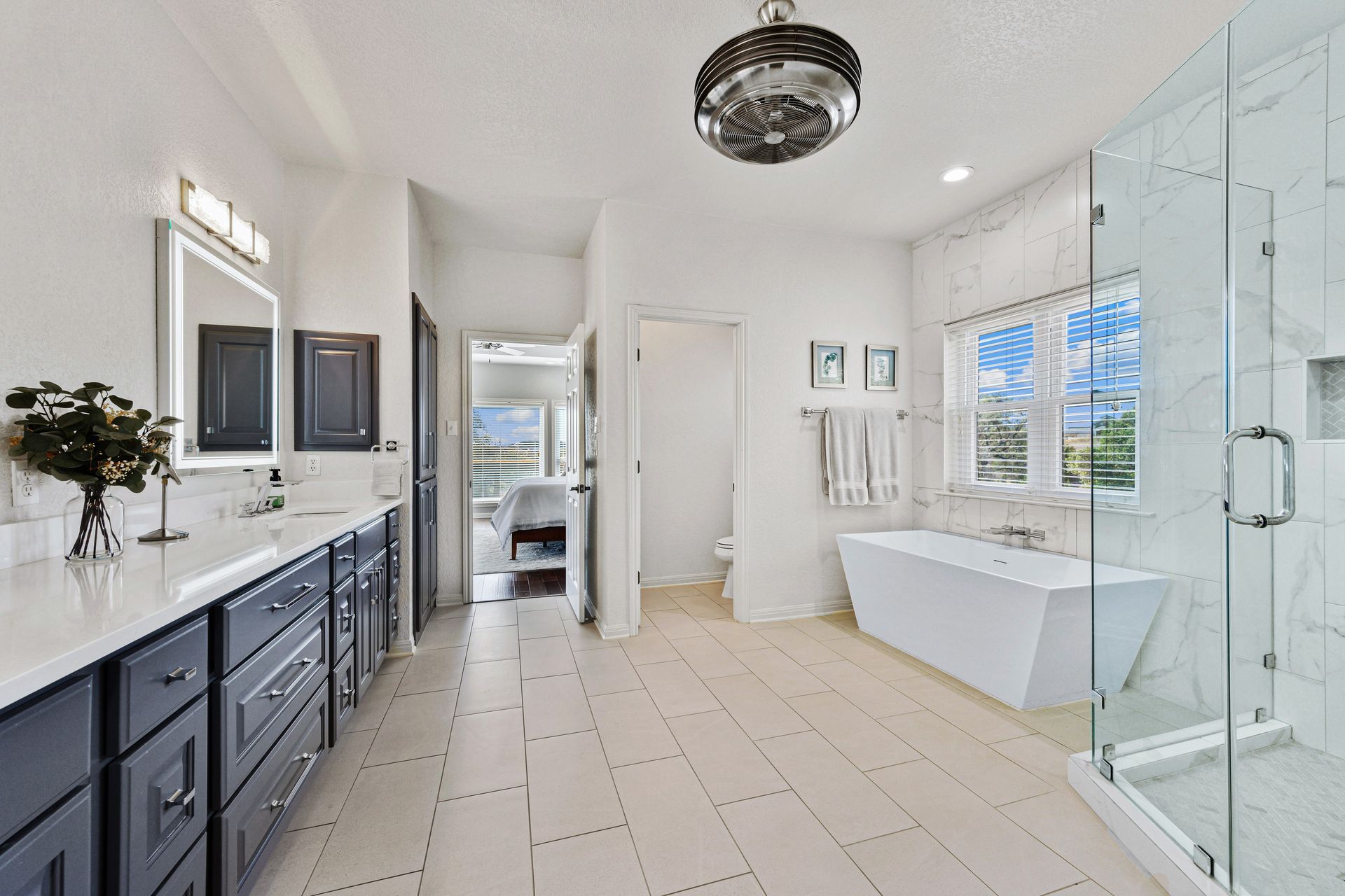 A modern bathroom built by a bathroom remodeler, featuring dark cabinets, a bathtub, and vanities. A modern bathroom built by a bathroom remodeler, featuring dark cabinets, a bathtub, and vanities.
