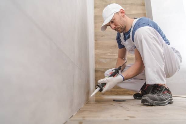 A man finishing a bathroom remodeling.
