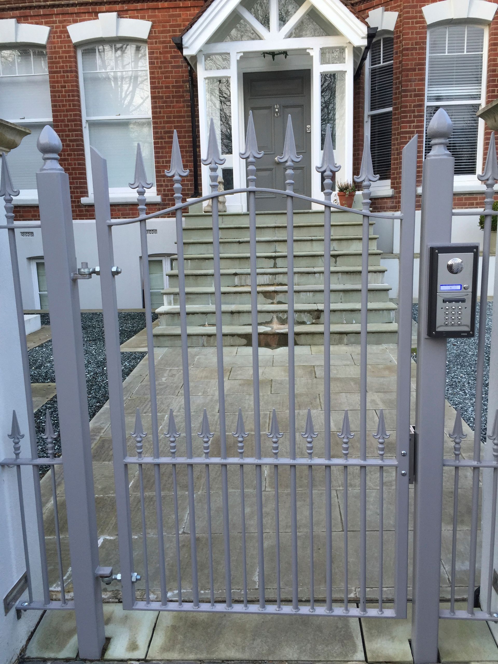 a wrought iron gate in front of a brick building