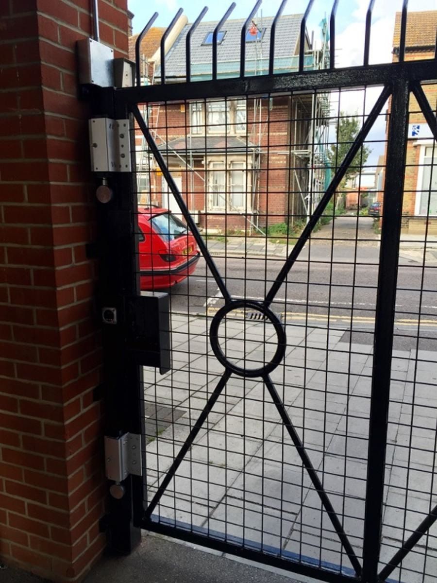 a red car is parked in front of a gate that says a on it