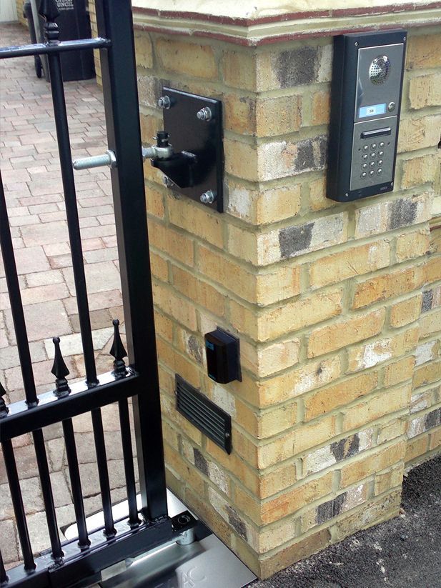 a brick wall with a gate and a phone on it