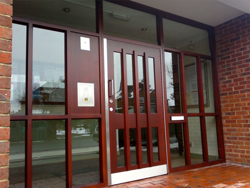a brick building with a wooden door and glass windows