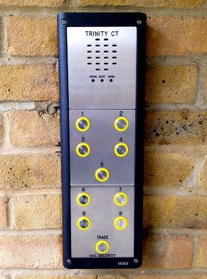 a stainless steel door entry system is mounted on a brick wall .
