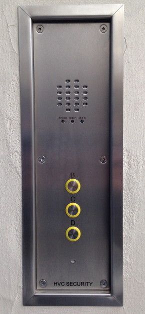 a stainless steel doorbell is mounted on a white wall .
